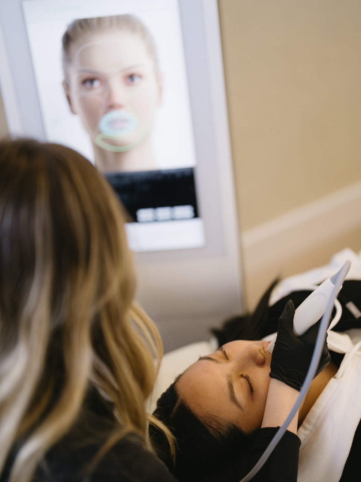 Provider using the UltraVision RF handpiece with ultrasound guidance on a client's jawline